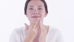 a woman wash a face with Neora cream